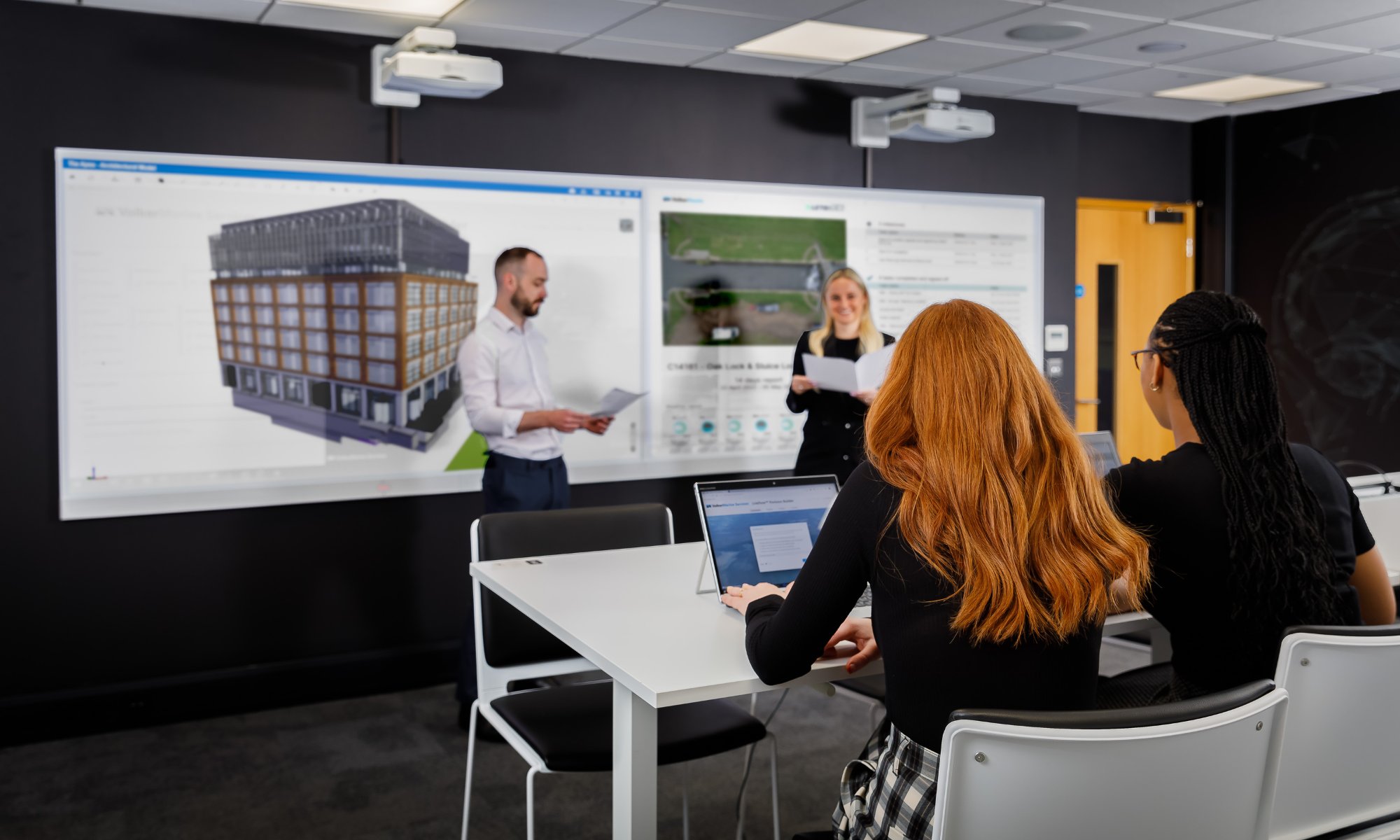 Two women look at projected screen in an office