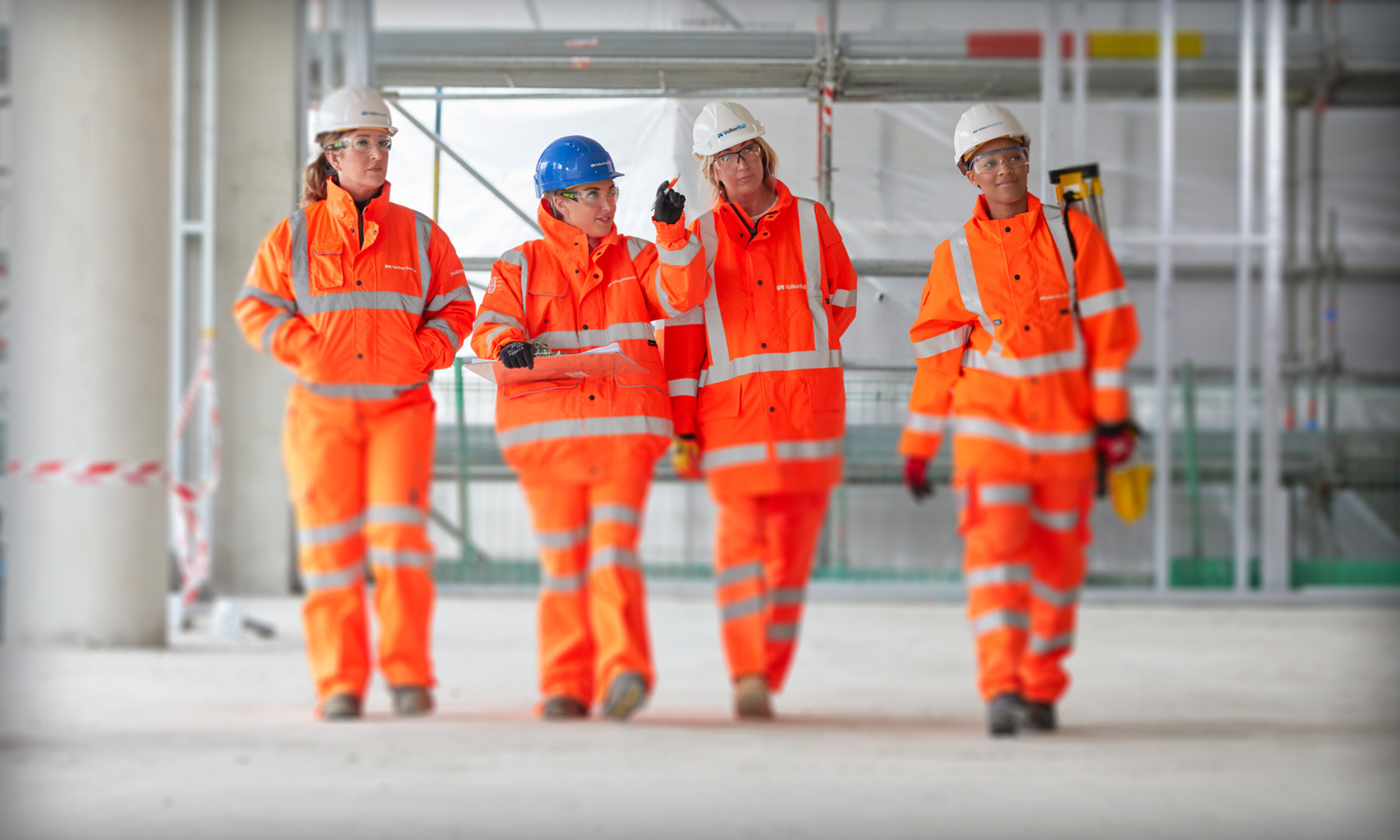 Female construction workers wearing orange high vis on site